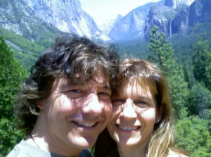 Mike and a friend smiling together with Yosemite Valley in the background