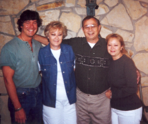 Mike with family members posing in front of a stone wall