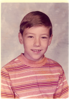 Mike as a boy in a striped shirt, school portrait