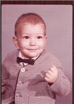 Mike as a toddler in a checkered jacket and bow tie, school portrait