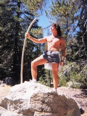 Mike standing on a rock holding a staff in the mountains